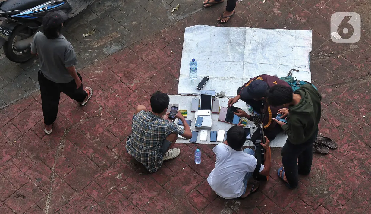 Pengunjung melihat-lihat handphone di Pasar Loak Lebayoran Lama, Jakarta, Jumat (9/9/2022). Pasar Loak Kebayoran Lama tetep eksis di tengah maraknya situs jual beli online atau daring. (Liputan6.com/Angga Yuniar)