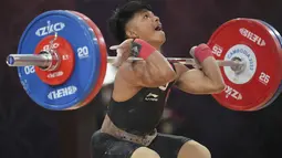 Muhammad Husni menjalani debutnya sebagai atlet angkat besi di SEA Games 2023 Kamboja. Husni sukses meraih medali perunggu dari nomor angkat besi 55 kilogram putra. (AP Photo/Tatan Syuflana)