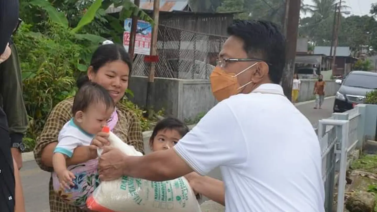 Bupati Agam, Indra Catri menyerahkan bantuan kepada masyarakat.