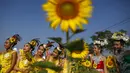 Sejumlah penari berpose di tengah bunga matahari yang bermekaran di sebuah ladang di Bangkok, Thailand, Rabu (13/1/2016). (REUTERS / Athit Perawongmetha)
