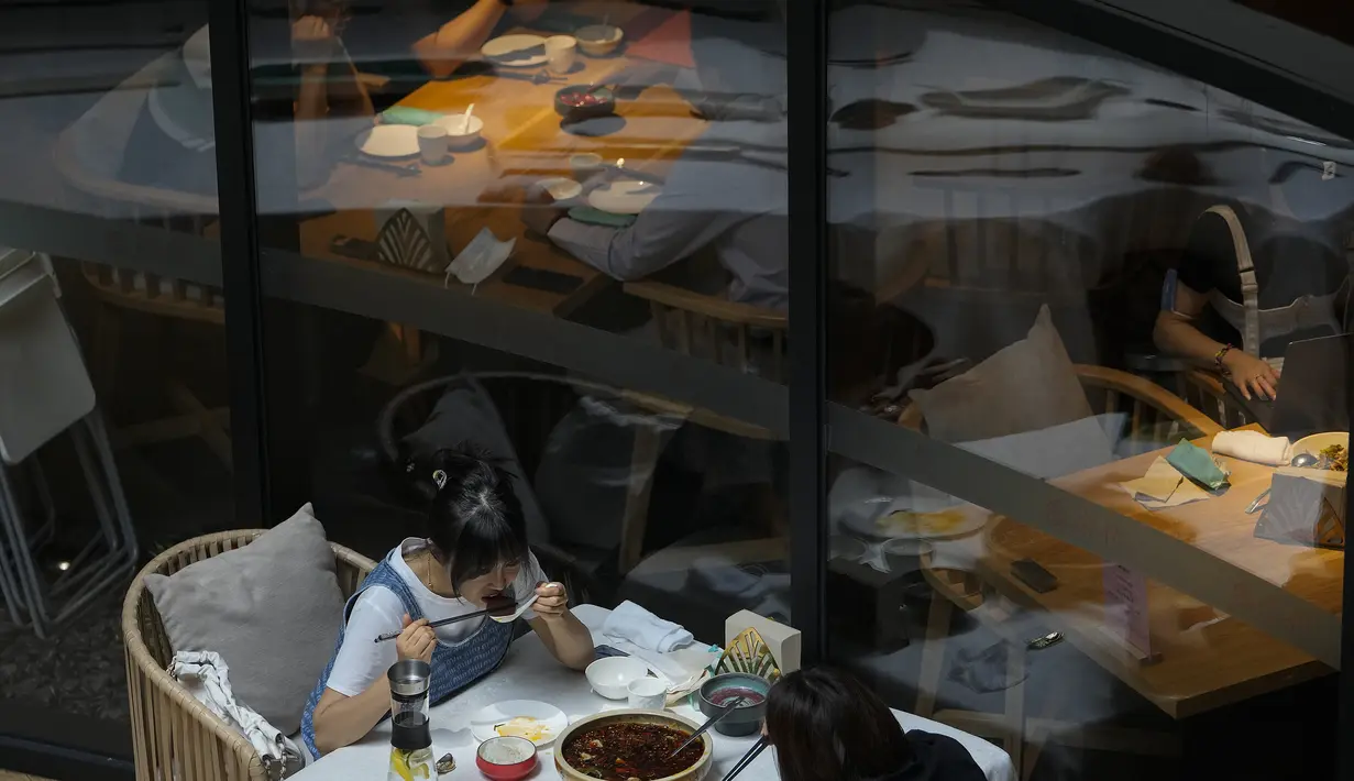 Orang-orang makan siang di restoran yang dibuka kembali di pusat perbelanjaan saat kasus COVID-19 turun di Beijing, Senin (6/6/2022). Pengunjung kembali ke restoran di sebagian besar Beijing untuk pertama kalinya dalam lebih dari sebulan sebagai pihak berwenang lebih lanjut melonggarkan pembatasan terkait pandemi wabah COVID-19. (AP Photo/Andy Wong)