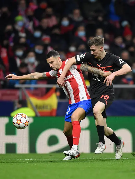 Bek Atletico Madrid Mario Hermoso (kiri) berebut bola dengan gelandang AC Milan Alexis Saelemaekers pada laga kelima Grup B Liga Champions 2021/2022 di Stadion Wanda Metropolitano, Kamis (25/11/2021) dini hari WIB. AC Milan menaklukkan tuan rumah Atletico Madrid 1-0. (OSCAR DEL POZO / AFP)