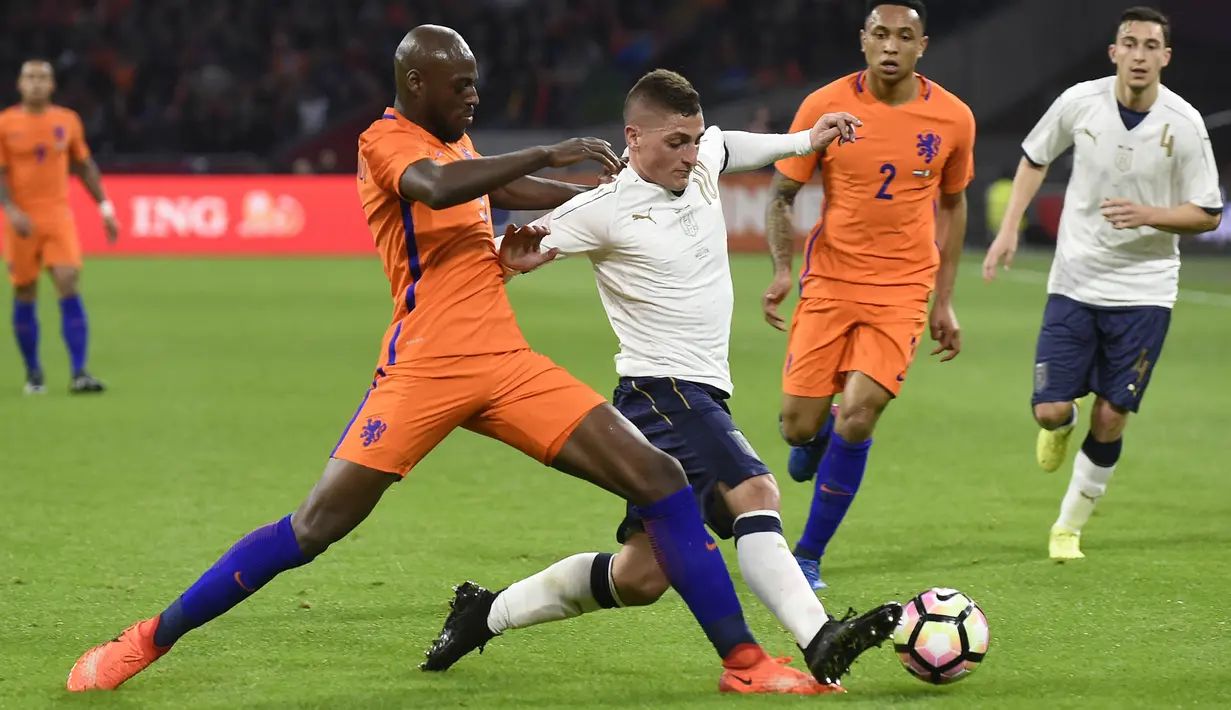 Bek Belanda, Bruno Martins, berusaha menghadang gelandang Italia, Marco Verratti. Pada laga tersebut Belanda memakai skema 4-3-3 sementara Italia dengan formasi 3-5-2. (AFP/ John Thys)