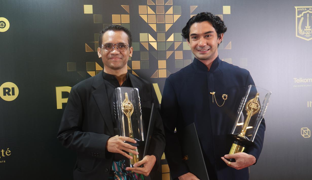 Felix K Nesi dan Reza Rahadian berfoto bersama Piala Citra FFI pada malam penganugerahan di Taman Ismail Marzuki (TIM) Jakarta pada Kamis (20/11/2025) malam. (Kapanlagi.com/Budy Santoso)