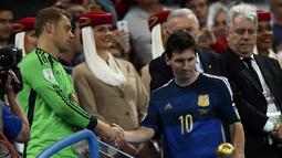Striker tim nasional Argentina itu tampak tak bersemangat saat mendapat ucapan selamat dari penjaga gawang Jerman, Manuel Neuer (kiri), Brasil, Senin (14/7/14). (REUTERS/Dylan Martinez)