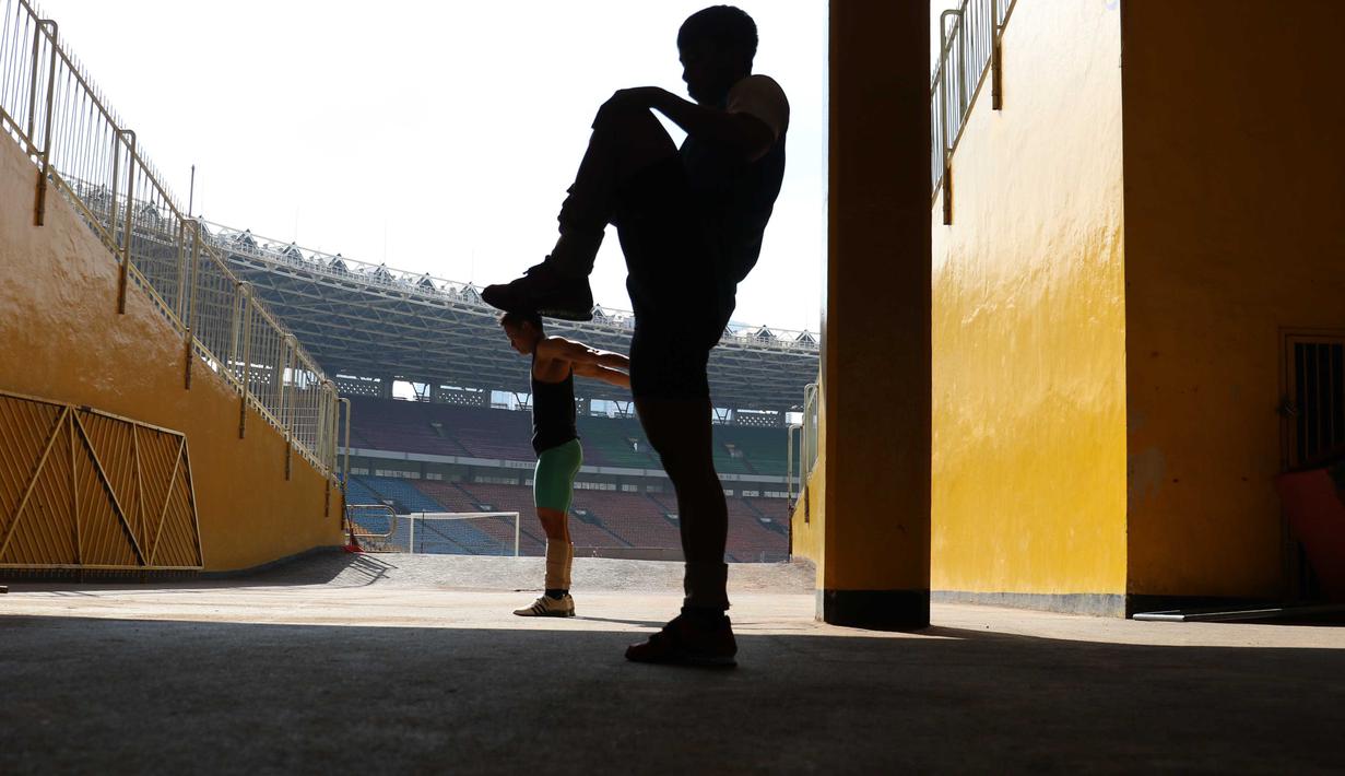 Atlet Angkat Besi Indonesia sedang melakukan pemanasan udekat pintu masuk Stadion GBK di Senayan, Jakarta, Senin (11/1/2016).  Hal ini karena tempat Latihan dalam tahap renovasi. (Bola.com/Nicklas Hanoatubun)