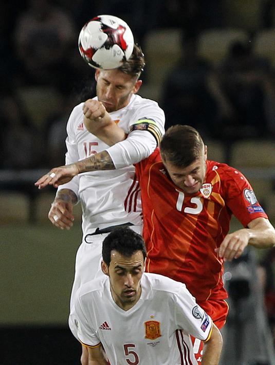 Sergio Ramos (atas) menghalau bola dari pemain Makedonia, Stefan Ristovski pada laga kualifikasi Piala Dunia 2018 grup G di Philip II National Stadium, Skopje, MaKedonia, (11/6/2017). (AP/Boris Grdanoski)