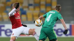 Pemain Arsenal, Emile Smith Rowe (kiri) berebut bola dengan Igor Perduta asal Vorskla Poltava saat bertanding pada laga kelima Grup E Liga Europa di Stadion NSK Olimpiyskiy, Kyiv, Ukraina, Jumat (30/11). Arsenal menang 3-0. (AP Photo/Efrem Lukatsky)