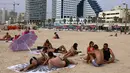 Orang-orang bersantai di pantai di kota pesisir Israel Tel Aviv (19/4/2021). Sebanyak 81 persen warga di atas usia 16 tahun mendapat vaksin, dan berdampak pada penurunan angka rawat inap dan penyebaran virus corona. (AFP/menahem kahana)
