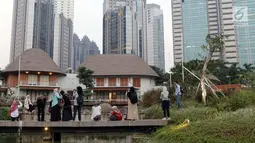 Warga menyalurkan hobi fotografi di area Hutan Kota Gelora Bung Karno, Jakarta, Kamis (20/6/2019). Sore hari banyak warga memanfaat waktu luang dengan berolahraga dan menyalurkan hobi fotografi di area Hutan Kota Gelora Bung Karno. (Liputan6.com/Helmi Fithriansyah)