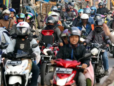 Polisi mengatur arus lalu lintas pemudik sepeda motor di Jalur Pantura Indramayu - Cirebon, Jawa Barat, Jumat (23/6). Iring-iringan pemudik bersepeda motor di sepanjang jalur pantura Indramayu - Cirebon mengular pada H-2 Lebaran (Liputan6.com/Johan Tallo)