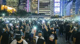 Mahasiswa menyalakan ponselnya sambil menyanyikan 'Do You Hear the People Sing' dari 'Les Miserables' selama rapat umum di Hong Kong (22/8/2019). Boikot ini disebabkan karena masa perkuliahan mendatang waktunya bertabrakan dengan unjuk rasa massa pro-demokrasi. (AFP Photo/Anthony Wallace)