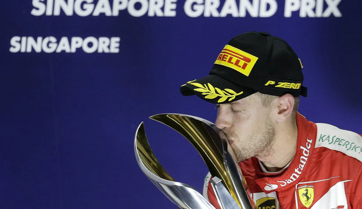 Sebastian Vettel mencium trofi juara F1 GP Singapura di Sirkuit Marina Bay, Singapura, Minggu (20/9/2015). (Reuters/Tim Chong)