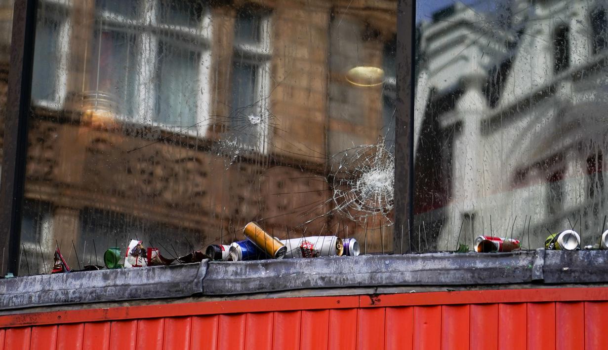 Jendela pecah sebuah toko makanan cepat saji di Leicester Square, London, setelah Italia mengalahkan Inggris dalam perebutan gelar juara EURO 2020, pada Senin (12/7/2021). Usai pertandingan, jalan-jalan di London juga dipenuhi sampah. (AP Photo/Alberto Pezzali)