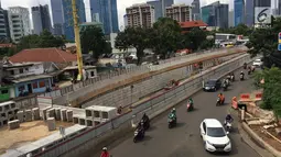 Kendaraan melintas di samping pembangunan proyek underpass Mampang-Kuningan, Jakarta, Senin (29/1). Underpass dengan panjang 860 meter ini kemungkinan besar baru bisa rampung pada April 2018 mendatang. (Liputan6.com/Immanuel Antonius)