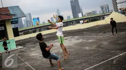 Seorang remaja menyundul bola saat bermain futsal di atas gedung di Pasar Mampang, Jakarta, Rabu (12/7).  Tempat bermain untuk anak-anak yang tidak berbayar masih sangat kurang di DKI Jakarta. (Liputan6.com/Faizal Fanani)