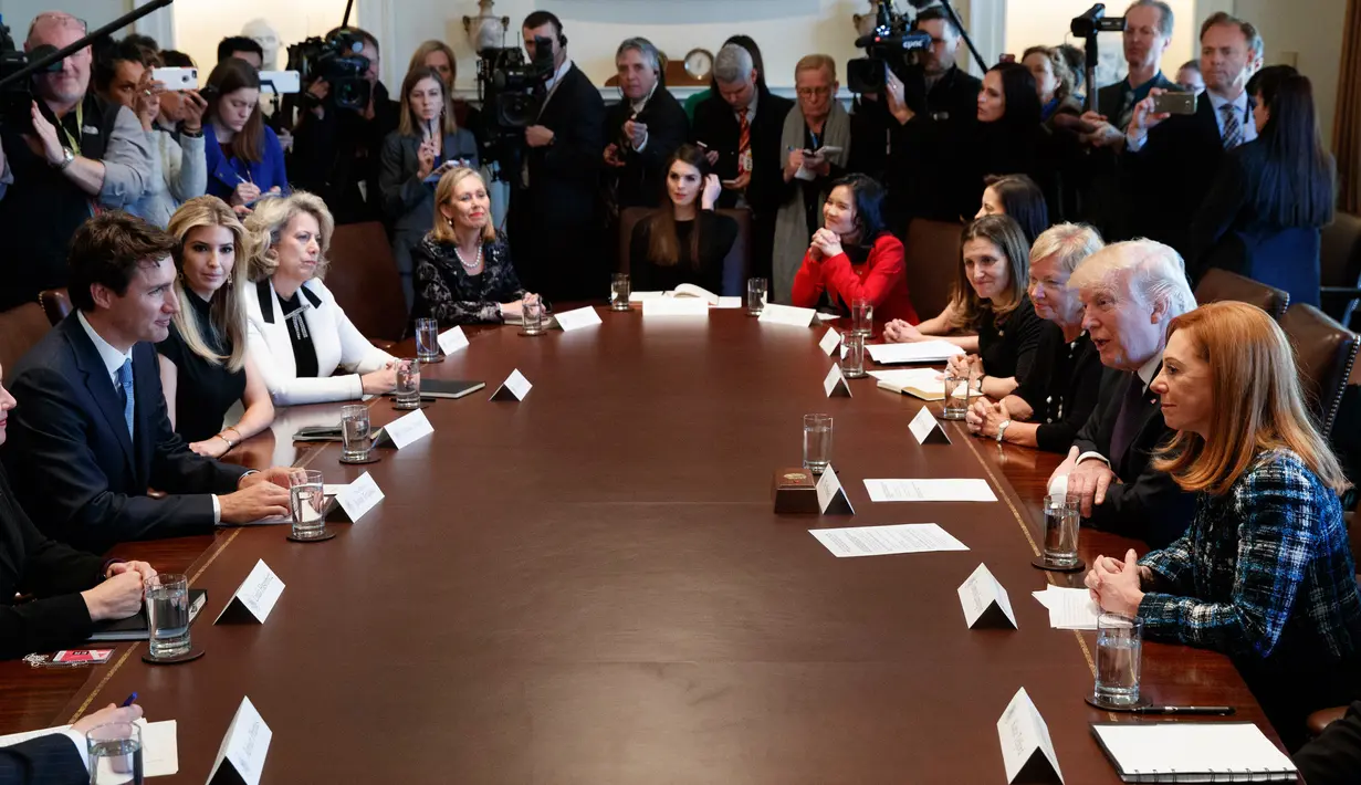 Presiden AS, Donald Trump dan PM Kanada, Justin Trudeau mengadakan pertemuan di meja bundar Oval Office, Gedung Putih, Washington, Senin (13/2). Pada pertemuan tersebut, terlihat Ivanka Trump duduk tepat di samping Trudeau. (AP Photo/Evan Vucci)