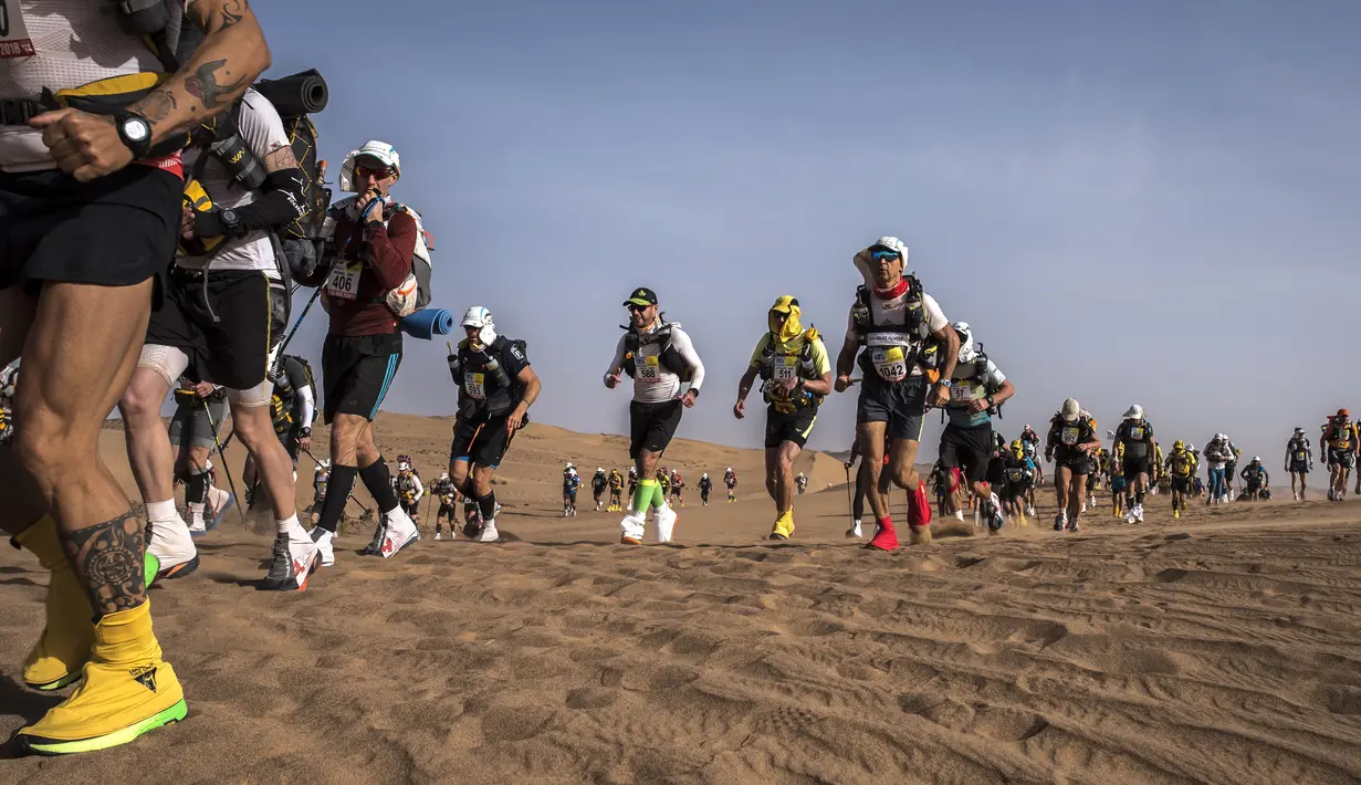 Sejumlah peserta bersaing dalam kejuaraan Marathon des Sables ke-33 tahap kedua di Gurun Sahara, selatan Maroko, Senin (9/4). Marathon ini menempuh perjalanan 6 hari dengan jarak tempuh sejauh 250 kilometer. (JEAN-PHILIPPE KSIAZEK/AFP)