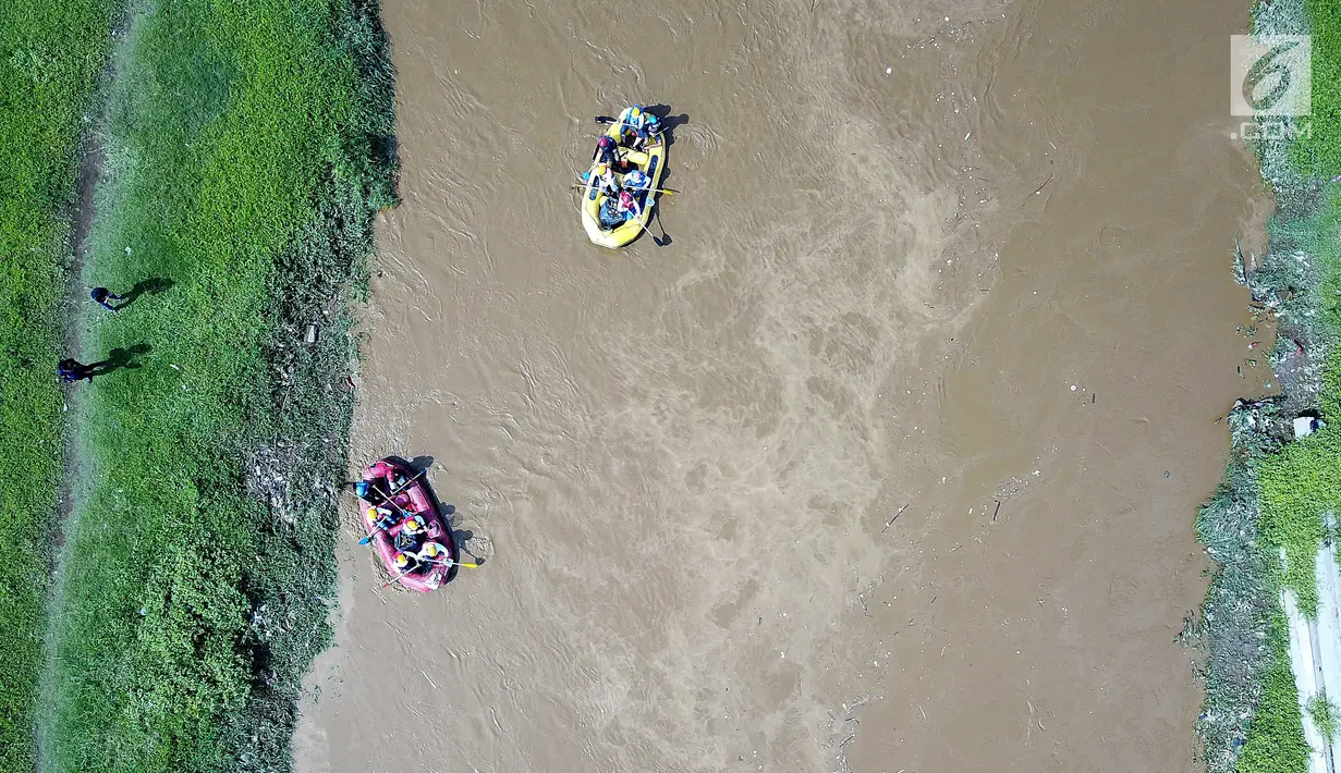 Peserta dengan perahu karet  menyusuri Sungai Ciliwung sambil membersihkan sampah pada acara Bersih-Bersih Sungai Ciliwung, Jakarta, Minggu (08/4). Kegiatan tersebut merupakan rangkaian HUT Kementerian BUMN. (Liputan6.com/Fery Pradolo)