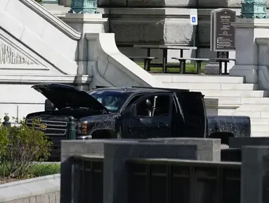 Pihak berwenang menyelidiki sebuah truk pikap yang diparkir di trotoar di depan Perpustakaan Kongres AS, di sebelah timur gedung Capitol, Washington, Kamis (19/8/2021). Seorang pria dalam kendaraan tersebut di parkiran mengaku memiliki sejumlah bahan peledak. (AP Photo/Alex Brandon)