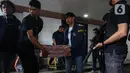 Petugas merapikan barang bukti usai sejumlah Menteri Kabinet Merah Putih memberikan keterangan terkait capaian desk pemberantasan perjudian daring dan desk keamanan siber dan perlindungan data di Kantor Kementerian Komunikasi dan Digital (Komdigi), Jakarta, Kamis (21/11/2024). (Liputan6.com/Angga Yuniar)