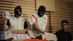 Penyidik KPK menunjukkan barang bukti disaksikan Pimpinan KPK Laode M Syarif dan Jubir  KPK Febri Diansyah saat memberikan keterangan Operasi Tangkap Tangan (OTT) Bupati Klaten di Gedung KPK, Jakarta, Sabtu (31/12). (Liputan6.com/Helmi Afandi)