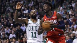 Pemain New Orleans Pelicans, Jrue Holiday (kanan) mencoba melewati pemain Boston Celtics, Kyrie Irving (11) pada laga NBA basketball game di TD Garden, Boston, (16/1/2018). Celtics kalah 113-116. (AP/Charles Krupa)
