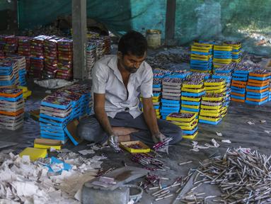 Seorang pekerja membuat petasan untuk festival Hindu Diwali di sebuah pabrik di pinggiran Ahmedabad, India (20/10/2021). Permintaan petasan sangat besar di India selama Diwali, festival lampu, yang akan dirayakan pada 4 November. (AP Photo/Ajit Solanki)