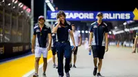 Sean Gelael (kanan) tengah melakukan track walk di Sirkuit Marina Bay bersama Carlos Sainz Jr (kiri) dan tim Toro Rosso jelang sesi latihan bebas pertama F1 GP Singapura. (Scuderia Toro Rosso)