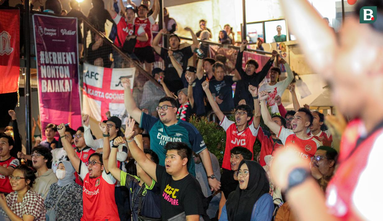 Pendukung Arsenal yang tergabung ke dalam AIS (Arsenal Indonesia Supporters) merayakan gol pertama timnya ke gawang Tottenham Hotspur yang dicetak oleh Pierre-Emile Hojbjerg saat Roaring Night Liga Inggris di The Ground at Nipah, Jakarta Selatan, Minggu (28/04/2024). (Bola.com/Bagaskara Lazuardi)