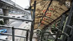 Coret-coretan menghiasi atap Jembatan penyeberangan orang (JPO) di Jalan Iskandarsyah Raya, Blok M, Jakarta, Kamis (23/8). Akibat kondisi JPO yang tidak layak itu banyak pejalan kaki memilih menyeberang di ruas jalan. (Liputan6.com/Faizal Fanani)