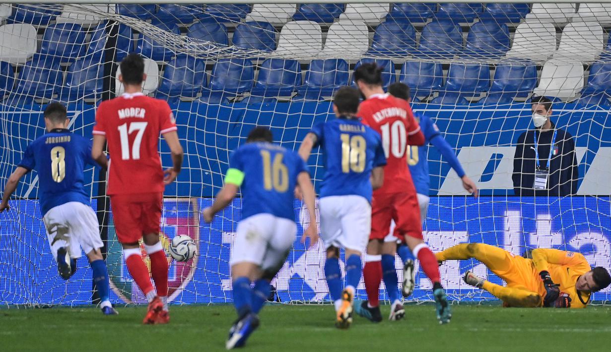 Gelandang Italia, Jorginho (kiri), sukses membuat gol dari tendangan penalti yang gagal diantisipasi kiper Polandia, Wojciech Szczesny dalam laga UEFA Nations League Grup A1 melawan Polandia di Stadion Mapei, Italia, Senin (16/11/2020) dini hari WIB. Italia menang 2-0 . (AFP/Miguel Medina)