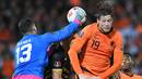 Kiper Gibraltar Bradley Banda (kiri) meninju bola melewati penyerang Belanda Wout Weghorst pada laga Kualifikasi Piala Dunia 2022 zona Eropa Grup G di De Kuip, Rotterdam, Selasa (12/10/2021) dini hari WIB. Menjamu Gibraltar, Belanda menang 6 gol tanpa balas. (JOHN THYS/AFP)