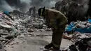 Seorang pemadam kebakaran beristirahat saat memadamkan api di pabrik daur ulang sampah di Ciudad Juarez, Meksiko (2/5). Pemerintah setempat menyarankan untuk tetap tinggal di dalam rumah dan menutup jendela serta pintu. (AP/Christian Torres)