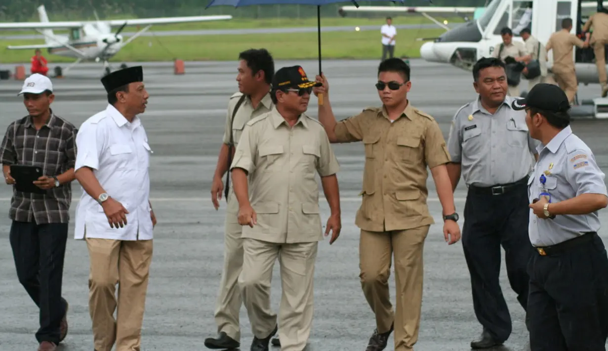 Kader Partai Gerindra, Fernando Wowor saat memayungi Ketua Umum Gerindra Prabowo Subianto. Ketua Tim Advokasi DPP Partai Gerindra Habiburokhman membenarkan Fernando memiliki kedekatan dengan Prabowo Subianto. (Facebook/Fernando Wowor)