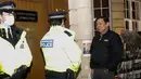 Duta Besar Myanmar untuk Inggris, Kyaw Zwar Minn berbicara dengan polisi di luar gedung Kedutaan Besar Myanmar di London, Rabu (7/4/2021). Dubes Myanmar tersebut juga mendapati bahwa dia diberitahu bahwa dirinya bukan lagi perwakilan di Inggris. (AP Photo/Alastair Grant)