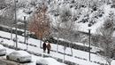 Warga melintasi jalan bersalju di Ankara, 23 Januari 2022.  Badai musim dingin dan hujan salju tetap berlaku di sebagian besar wilayah Turki, menyebabkan penutupan jalan antara ribuan desa dan kota di banyak daerah, beberapa hari setelah salju turun menyelimuti negara itu. (Adem ALTAN / AFP)