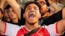 Seorang pendukung Arsenal yang tergabung ke dalam AIS (Arsenal Indonesia Supporters) memberikan dukungan kepada timnya saat Roaring Night Liga Inggris melawan Tottenham Hotspur di The Ground at Nipah, Jakarta Selatan, Minggu (28/04/2024). (Bola.com/Bagaskara Lazuardi)