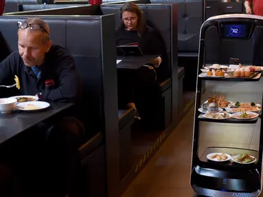 Robot mengantarkan makanan di restoran Asia di Wina, Austria, Kamis (28/5/2020). Restoran tersebut menggunakan robot untuk mengantar makanan guna mengurangi kontak yang tidak diperlukan antara pelayan dan pelanggan di tengah pandemi virus corona COVID-19. (Xinhua/Guo Chen)