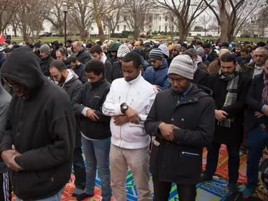 Warga Muslim melaksanakan Salat Jumat berjamaah di depan Gedung Putih, Washington DC, Amerika Serikat (AS), Jumat (8/12). Para warga muslim ini memprotes keputusan Presiden AS Donald Trump mengakui Yerusalem sebagai ibu kota Israel. (mari matsuri / AFP)