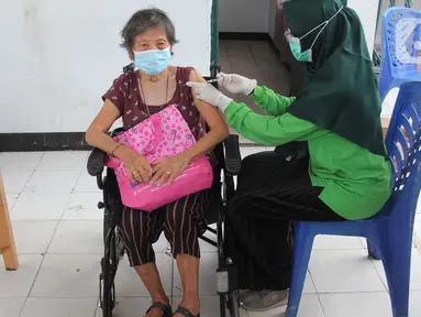 Petugas menyuntikkan vaksin COVID-19 dosis ketiga kepada lansia saat vaksinasi booster COVID-19 dari rumah ke rumah di Poris Plawad, Tangerang, Jumat (21/1/2022). Pelaksanaan vaksinasi dari rumah ke rumah untuk memudahkan para lansia mendapatkan vaksin booster COVID-19. (merdeka.com/Arie Basuki)