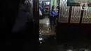 Seorang warga berdiri di tengah banjir yang melanda Jalan Bangka, Jakarta, Rabu (4/1/2023). Hujan deras yang terjadi pada Rabu sore membuat Kali Mampang meluap hingga menyebabkan banjir di kawasan tersebut dengan ketinggian bervariasi mulai dari 40 hingga 60 cm. (Liputan6.com/Herman Zakharia)