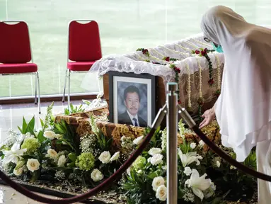 Seorang wanita berada dekat peti jenazah almarhum Ketua Umum Pengurus Besar Persatuan Atletik Seluruh Indonesia (PB PASI) Bob Hasan di Jakarta, Selasa (31/3/2020). Bob Hasan meninggal dunia di RSPAD Gatot Subroto Jakarta setelah sempat dirawat intensif selama tiga bulan. (Liputan6.com/Faizal Fanani)