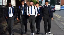 Pelajar Holyrood Secondary School saat kembali bersekolah di tengah pelonggaran lockdown akibat pandemi virus corona (Covid-19) di Glasgow, Skotlandia, Rabu (12/8/2020). Sebelumnya mereka diliburkan akibat penyebaran wabah pandemi yang melanda Skotlandia sejak Maret lalu.  (AFP/ANDY BUCHANAN)