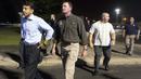 Gubernur Louisiana Bobby Jindal (kiri) saat meninggalkan gedung bioskop Lafayette , Louisiana, AS, Kamis (23/7/ 2015). Kabarnya Penembakan itu terjadi pukul 19.00 waktu setempat di saat mereka menonton film " Train Wreck ". (REUTERS/Lee Celano)