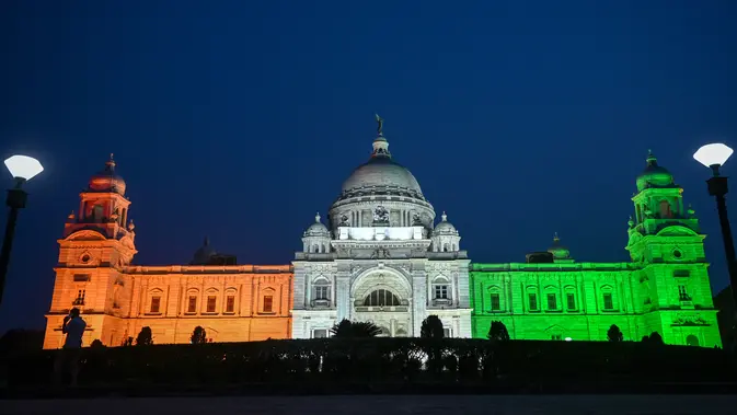 Victoria Memorial diterangi dengan bendera nasional India pada malam Hari Kemerdekaan India di Kolkata pada 14 Agustus 2023. (Photo by Dibyangshu SARKAR / AFP)