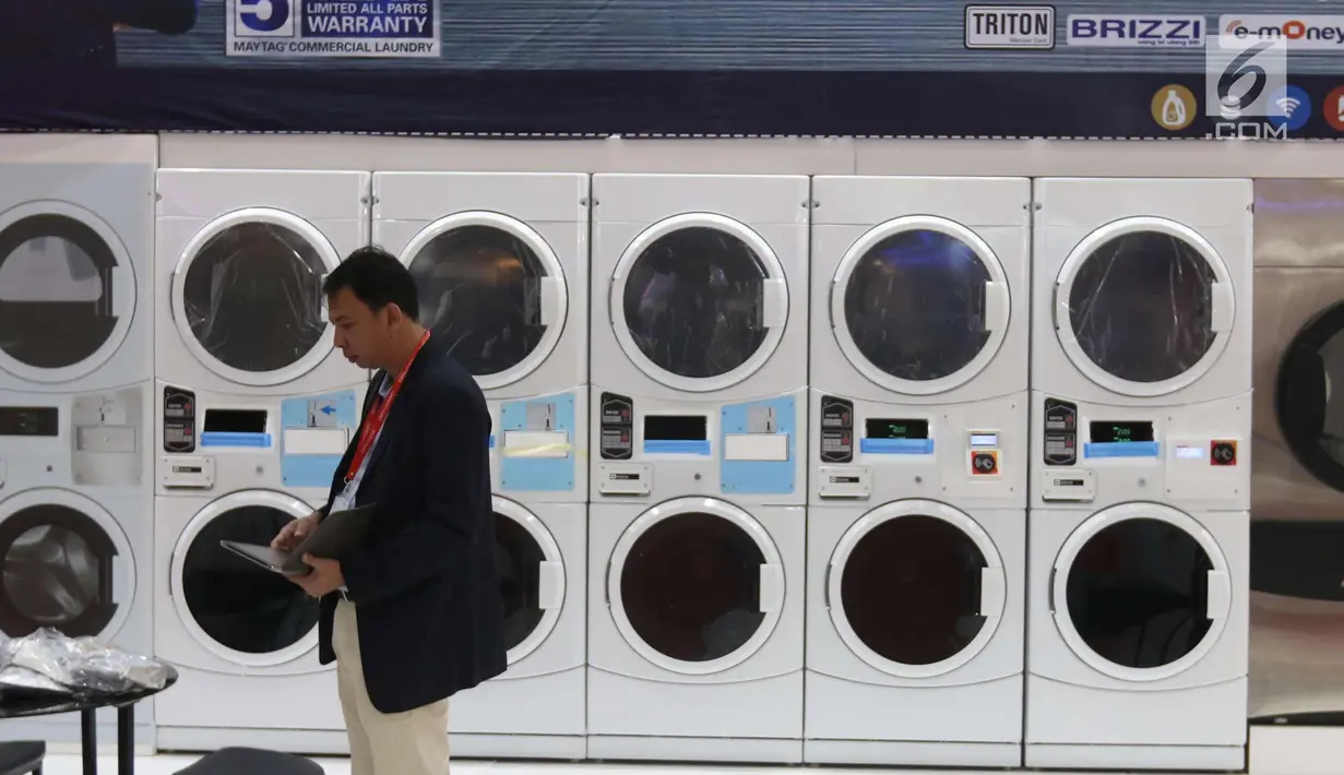 Penjaga stan melintas di depan mesin cuci di pameran Expo Clean dan Expo Laundry 2018, Jakarta, Selasa (27/3). Pameran tersebut merupakan pameran dagang yang menampilkan produk dan jasa dalam industri cleaning dan laundry. (Liputan6.com/Angga Yuniar)