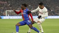 Pemain Crystal Palace, Michael Olise, diadang gelandang Manchester United (MU) saat kedua tim bertanding di Selhurst Park dalam lanjutan Liga Inggris 2023/2024, Selasa (7/5/2024). (AP Photo/Ian Walton)