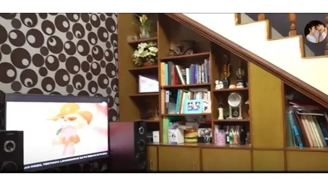 Ruang tv dirumah masa kecilnya tersebut terlihat nyaman dan terdapat buku yang ditata dengan rapi.