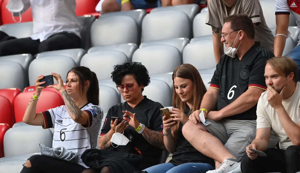 Jessica Kroos (tengah), istri dari gelandang Jerman Toni Kroos, mengambil gambar dengan ponselnya menjelang pertandingan sepak bola Grup F UEFA EURO 2020 antara Prancis dan Jerman di Allianz Arena di Munich pada 15 Juni 2021. (AFP/Pool/Matthias Hangst)